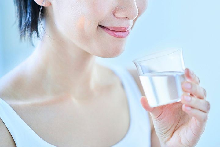 コップの水を飲む女性