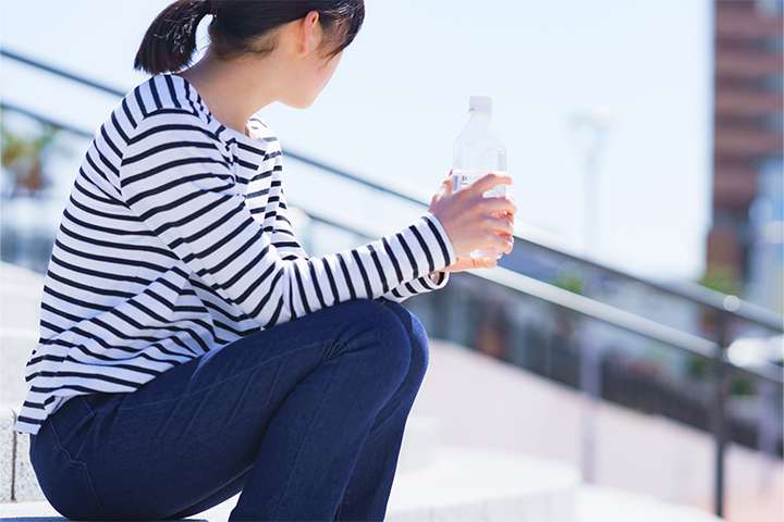 階段に座って水分補給をする女性