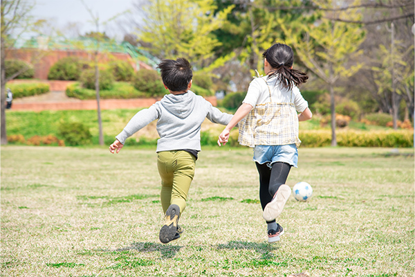 芝生を駆ける男の子と女の子