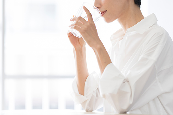 コップの水を飲んでいる女性