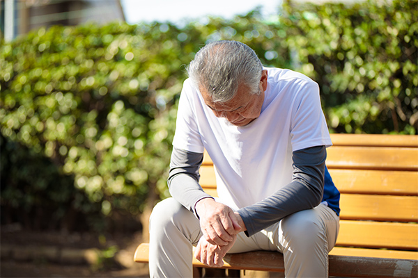 ベンチで息を整える年配の男性