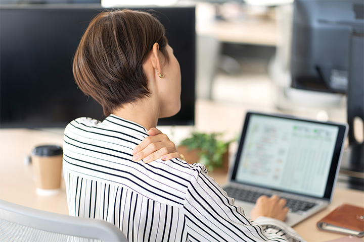 パソコン作業で肩こりを感じている女性