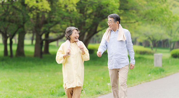 屋外でウォーキングする年配の夫婦