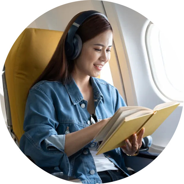 イメージ写真：飛行機座席で読書をしている女性
